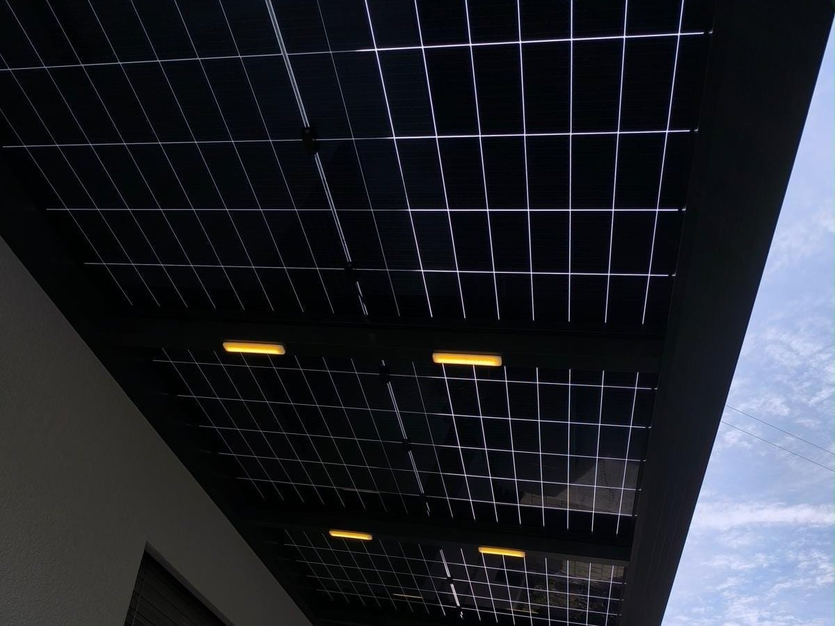 Blick von unten auf die Solarmodule: zwischen den Zellen fällt Tageslicht durch